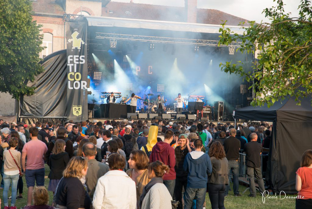 site du festival Festicolor 2015 avec les festivaliers sur l'herbe devant la scène pendant une changement de plateau